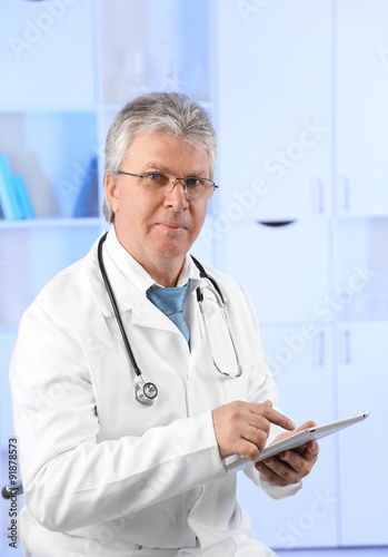 Doctor with digital tablet at his workplace