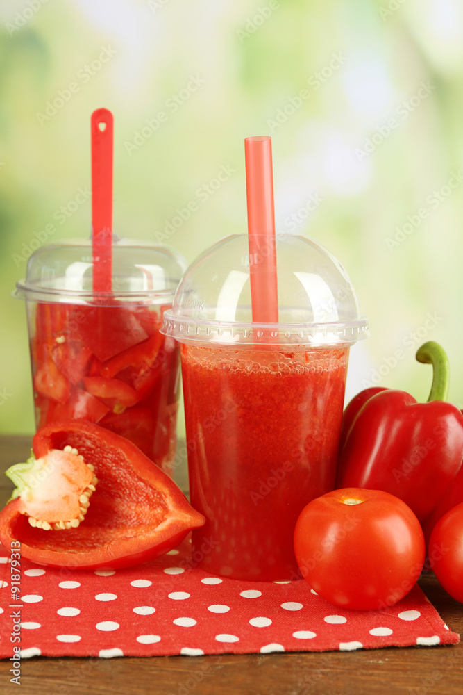 Red vegetable and fruit salad and healthy fresh drink in plastic cups on wooden background. Colorful diet concept Red vegetable and fruit salad and healthy fresh drink in plastic cups on wooden background. Colorful diet concept