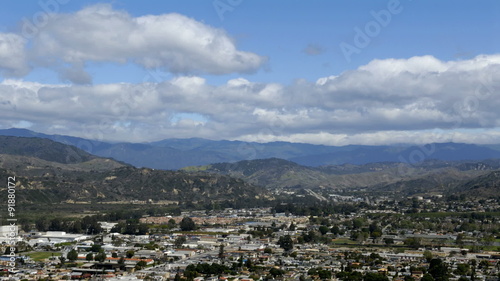 Time-lapse of clouds over city and mountains.