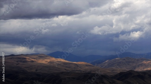 Time-lapse of rainclouds over mountains.