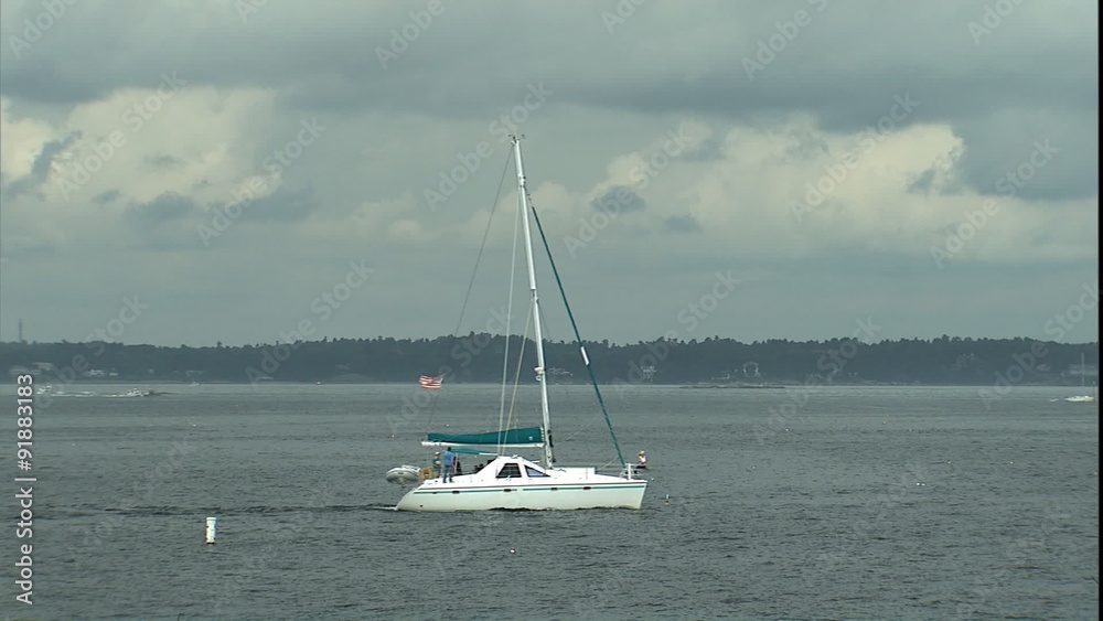 Catamaran sail boat motoring out of harbor Catamaran sail boat motoring out of harbor