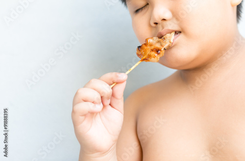 Fat boy eat grilled pork © kwanchaichaiudom