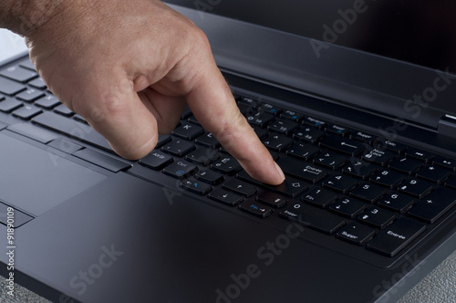 Finger Pressing the Enter Key on a Laptop Keyboard