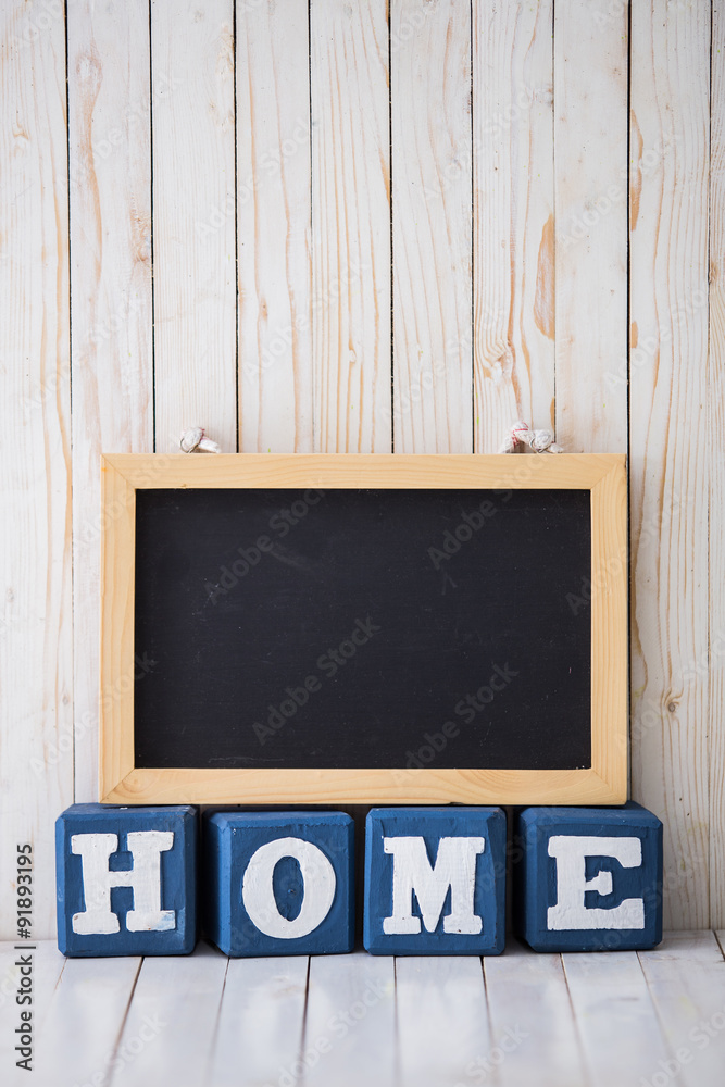 Chalkboard and HOME sign made of wooden blocks on wooden backgro