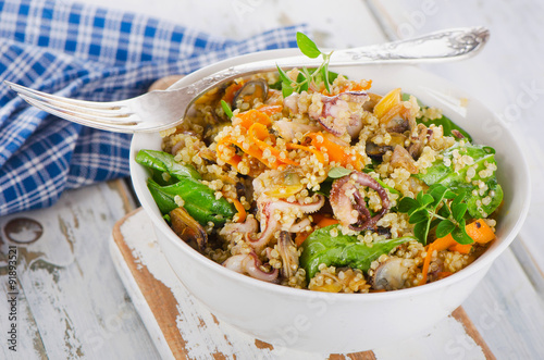 Salad with quinoa and seafood in bowl.