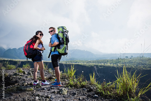 Mixed couple go trekking together, nature background
