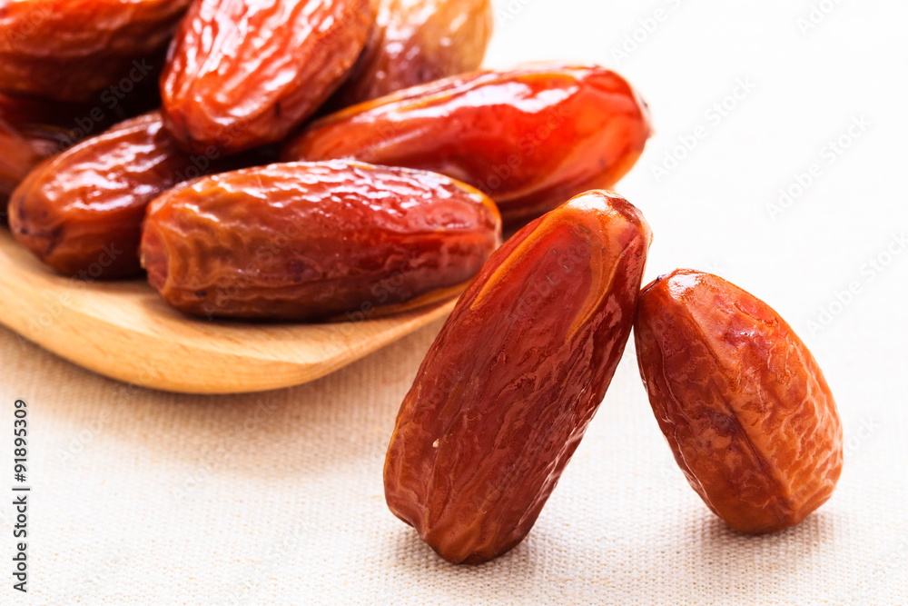 dried dates on wooden spoon cloth background dried dates on wooden spoon cloth background