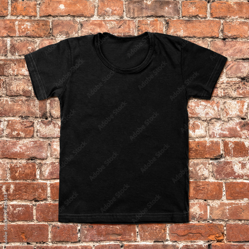 Black blank t-shirt on dark brick background Black blank t-shirt on dark brick background