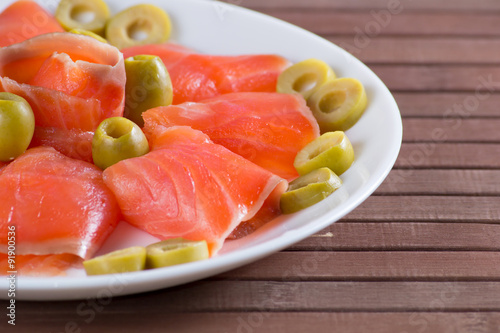 Sliced salted salmon served with olive