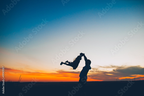 silhouette of a father and daughter on a background sunset