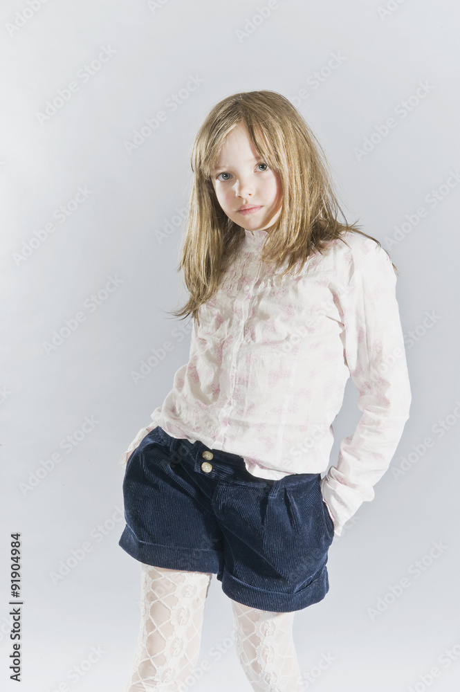 Portrait of a five year old girl in a light shirt and shorts.. Portrait of a five year old girl in a light shirt and shorts..