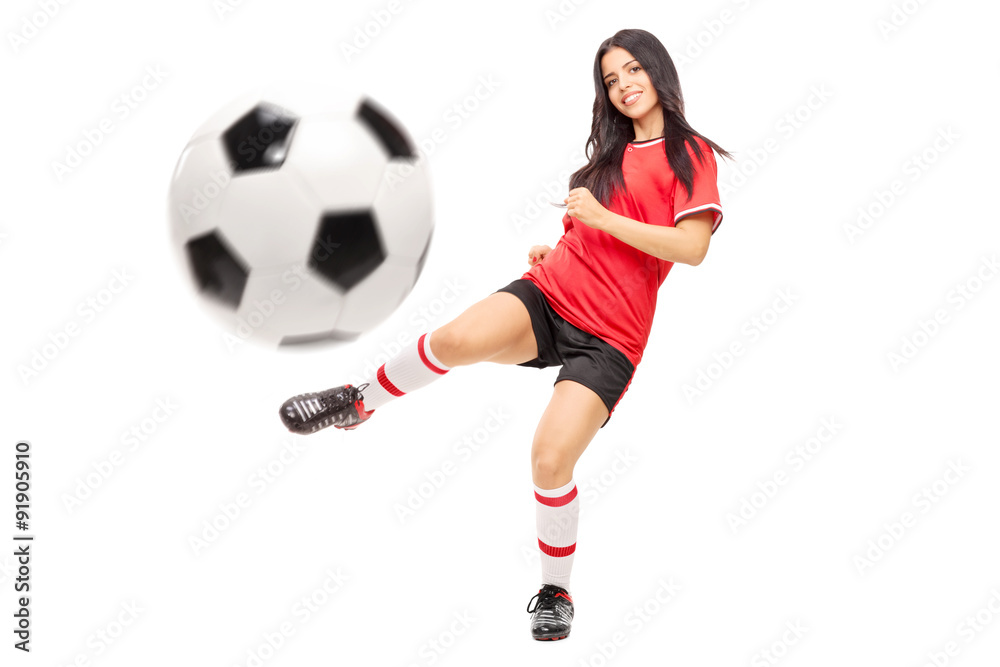 Beautiful female football player shooting a ball