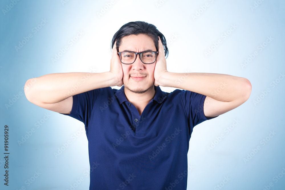 Handsome Asian man looking up while holding glasses with hand, o Handsome Asian man looking up while holding glasses with hand, o