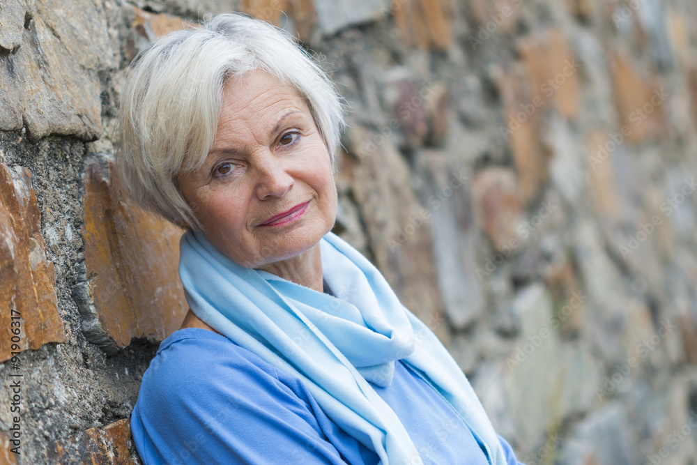 confident natural senior women posing at brick wall confident natural senior women posing at brick wall