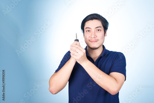 фотографія Asian handsome man with the keys of his new car, on blue backgro