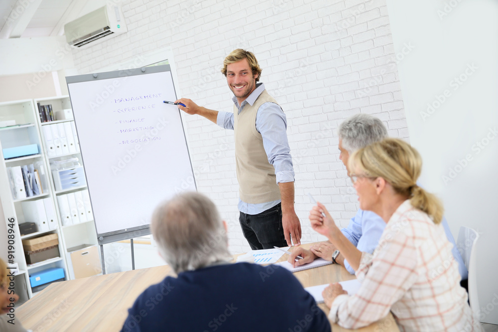 Business instructor leading meeting with senior training group Business instructor leading meeting with senior training group