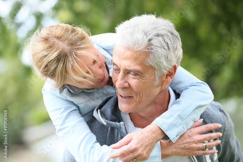 Senior man giving piggyback ride to his wife