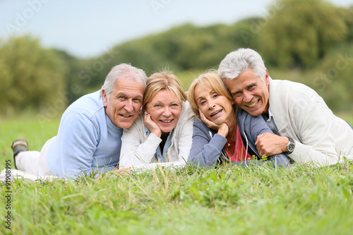 Portrait of senior people laying in grass