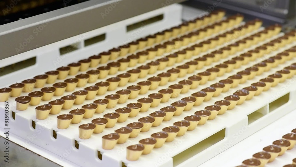 Fliessband mit Pralinen in einer Fabrik für Süßwaren // Conveyor with chocolates in a factory of food industry Fliessband mit Pralinen in einer Fabrik für Süßwaren // Conveyor with chocolates in a factory of food industry