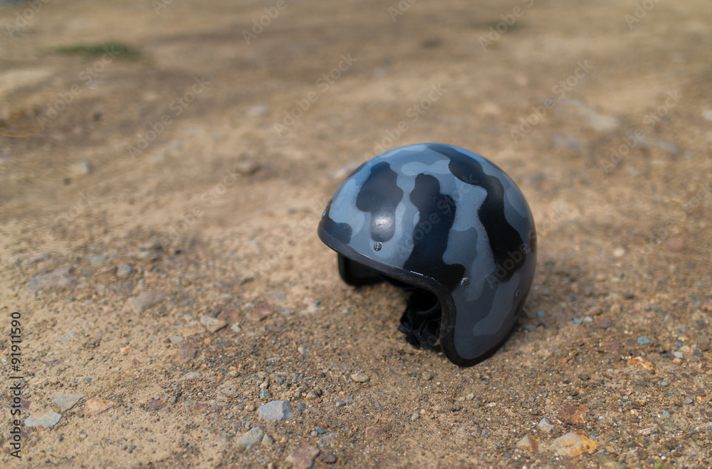 Obraz premium Scratched helmet on ground. Selective focus.