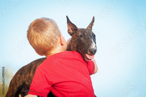 Obraz na plátně Friendship of bullterrier dog and little boy