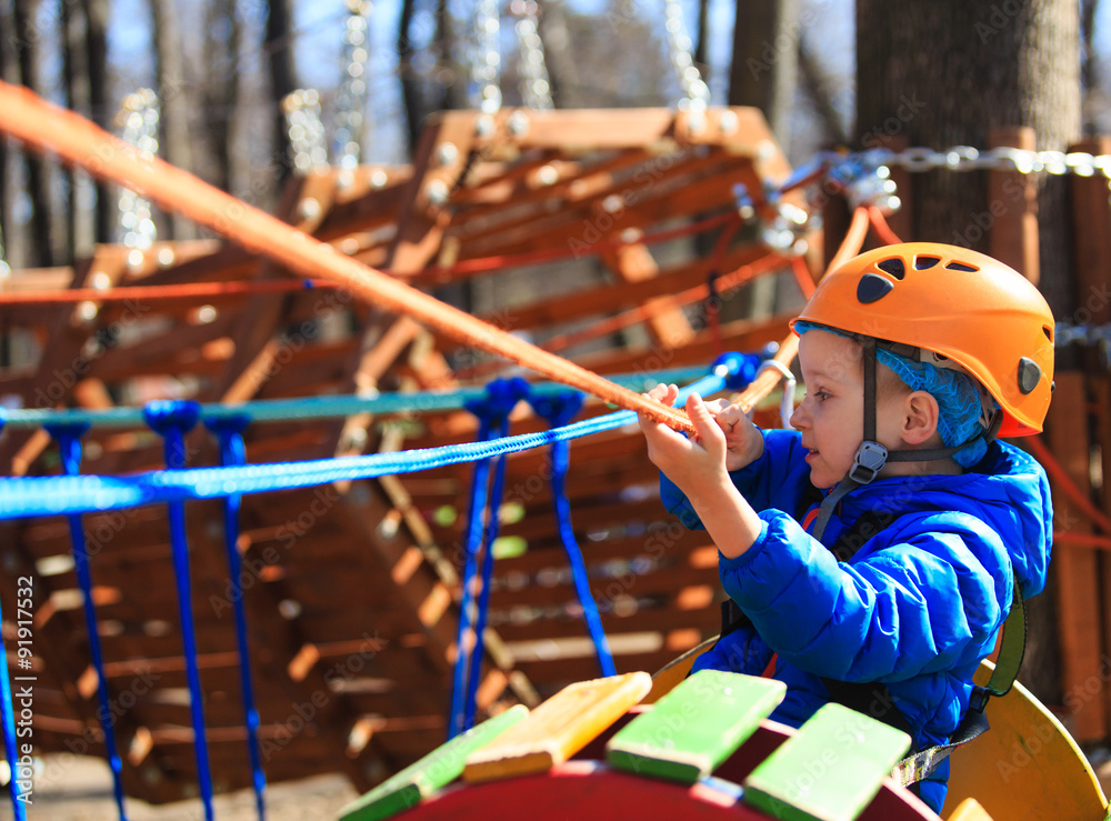 little boy climbing in adventure activity park
