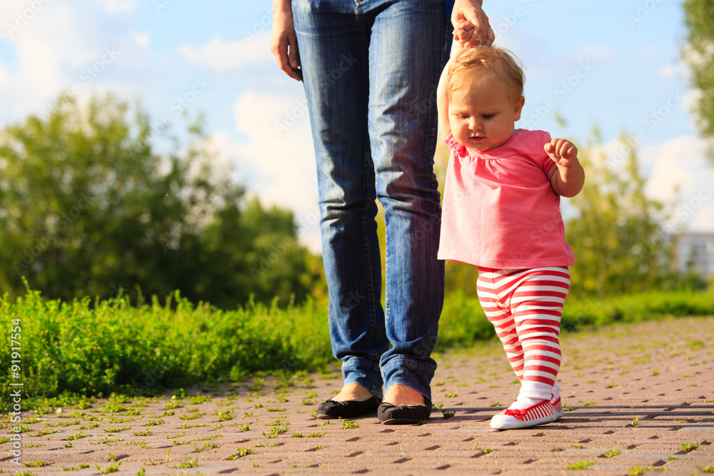 Obraz premium little girl making first steps in the park