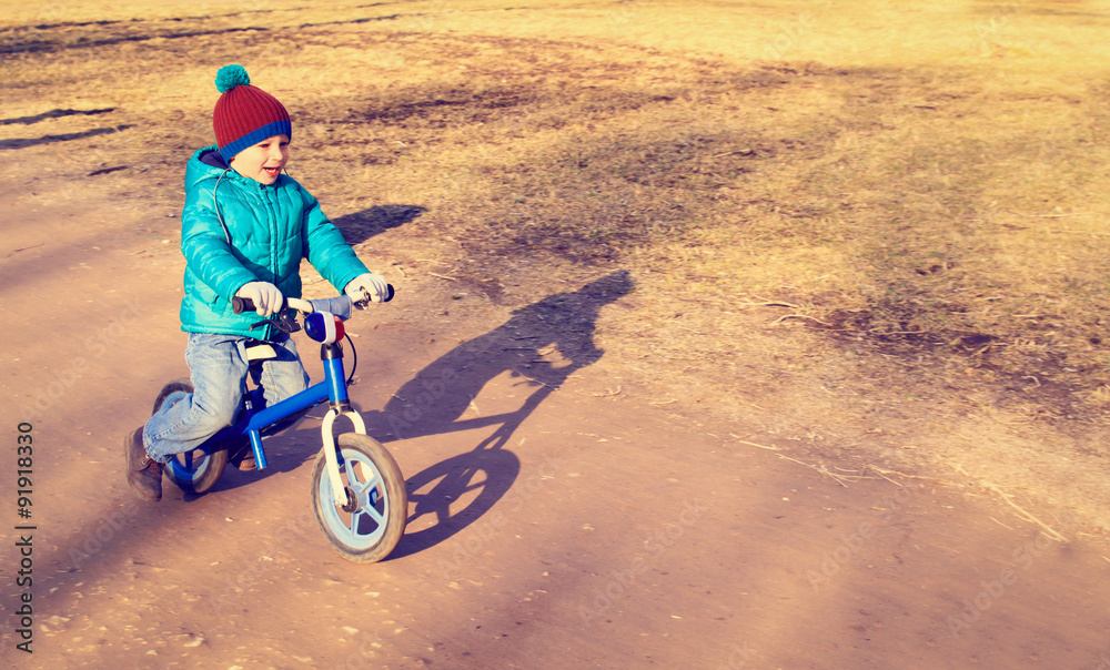 Obraz premium little boy on running bike outdoors, kids sport
