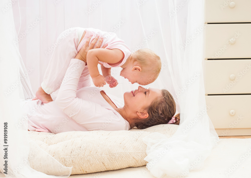 Mother and baby playing and smiling. Happy family.Home interior. Mother and baby playing and smiling. Happy family.Home interior.