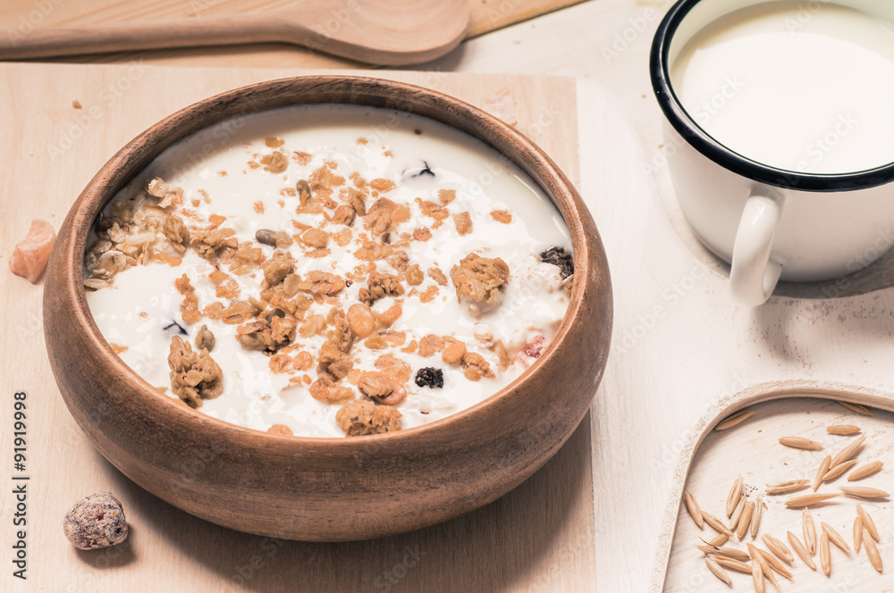 Muesli with milk in a rustic wooden bowl Muesli with milk in a rustic wooden bowl