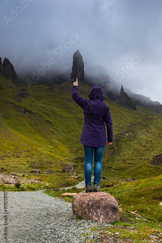 Woman pointing to the Old Man of Storr natural monument. Scotland