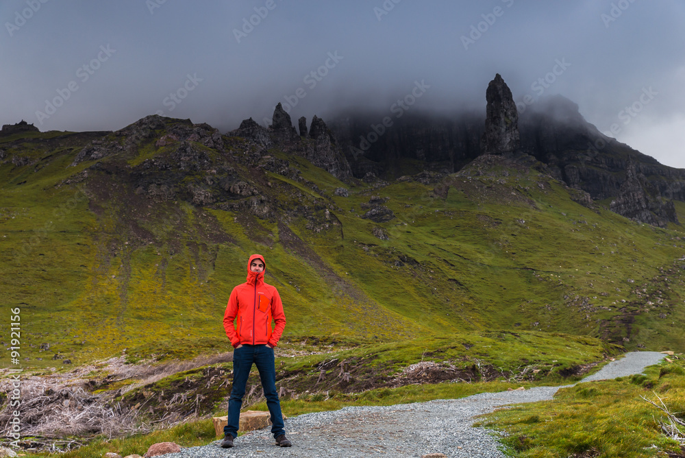 Obraz premium Man standing, looking at the Old Man of Storr, Scotland