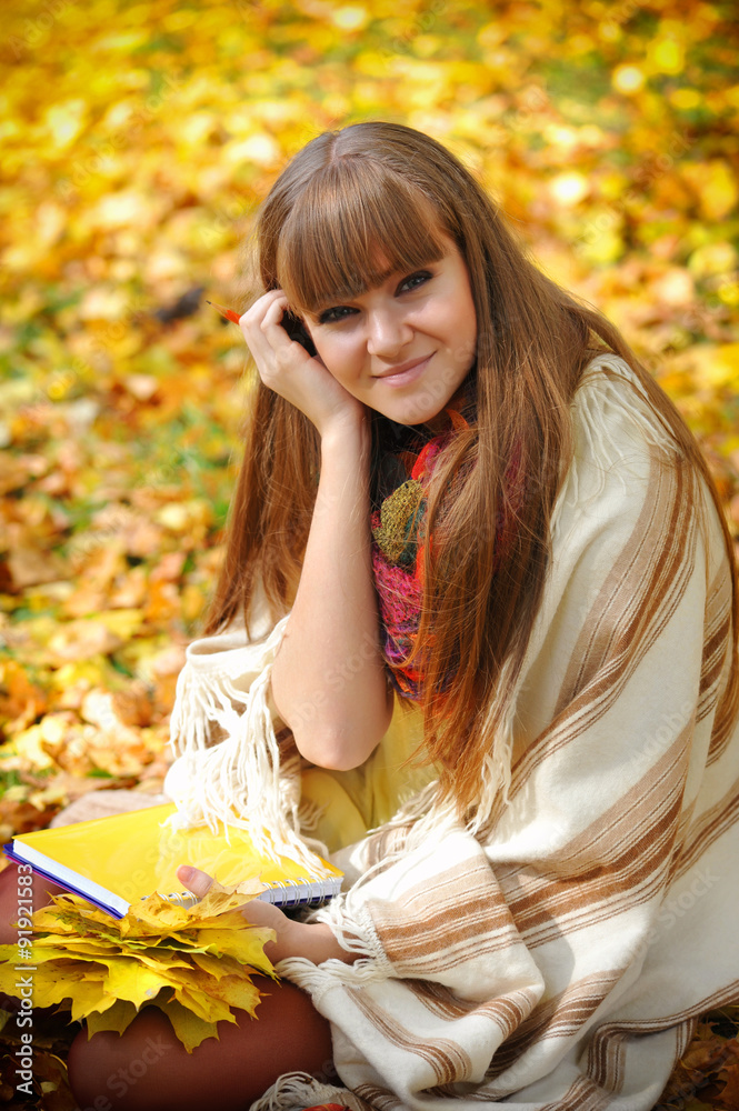 Beautiful girl with notebook on a background autumn leaves Beautiful girl with notebook on a background autumn leaves