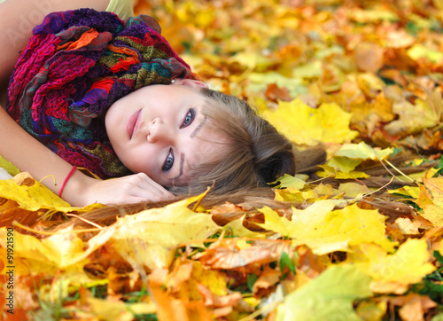 Portrait of beautiful young woman with autumn leaves