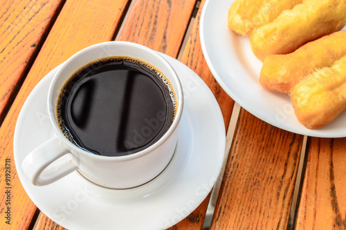 Coffee cup with patongko on wood table, coffee break