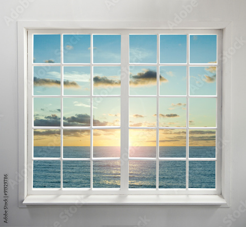 Fototapeta Nowoczesne okno mieszkalne z widokiem na morze podczas zachodu słońca