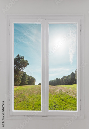 Residential window with trees and sky behind