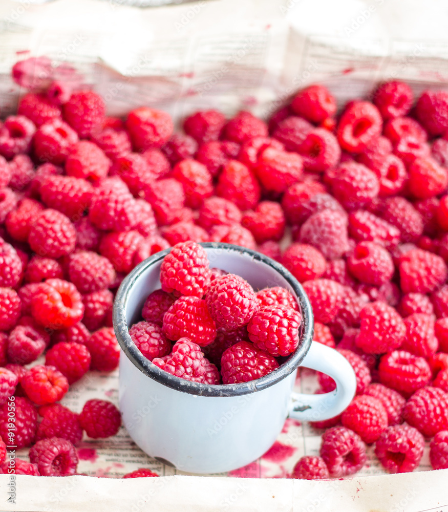 fresh red raspberries in a metal mug and placer fresh red raspberries in a metal mug and placer