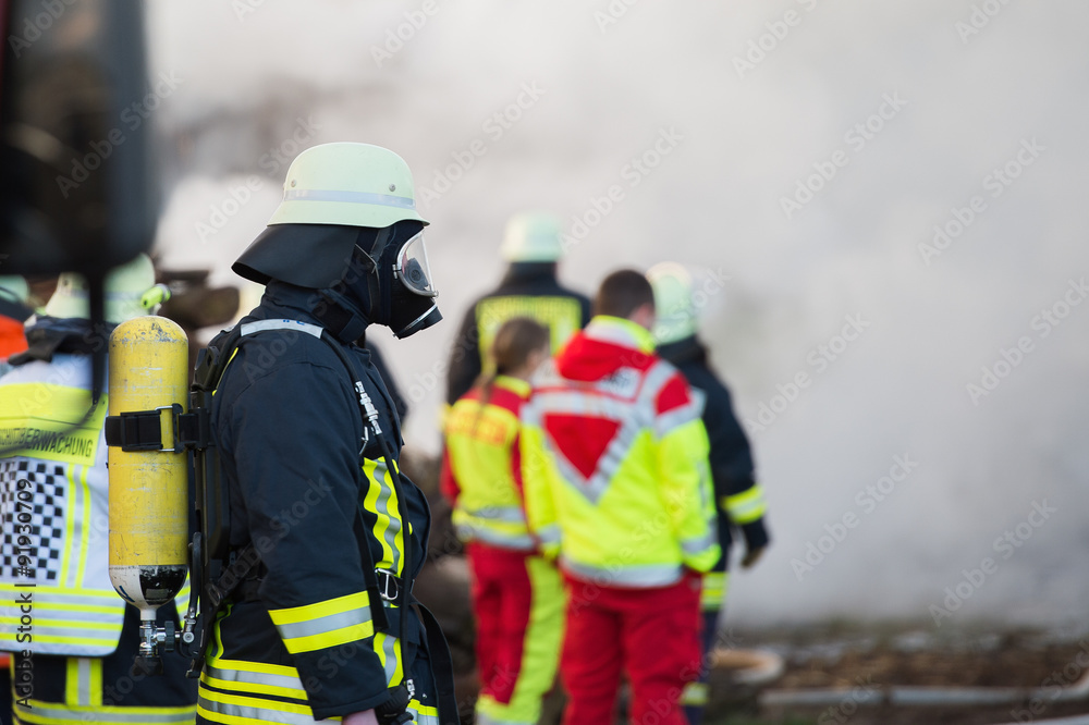 Obraz premium Strażak przed chmurą dymu