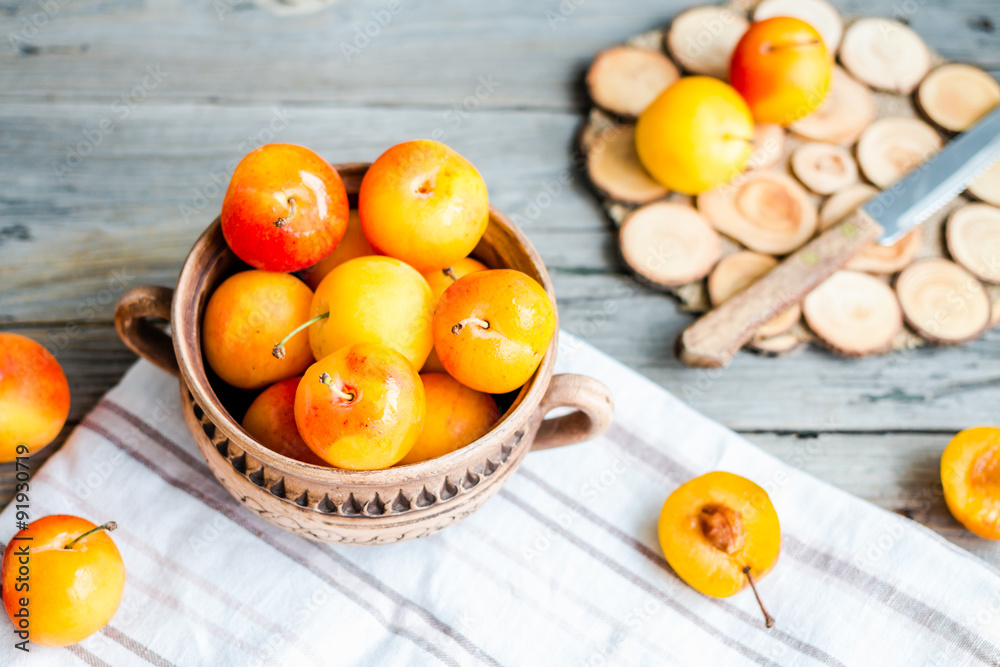 organic yellow plums in pottery on gray wooden table, rustic, to organic yellow plums in pottery on gray wooden table, rustic, to