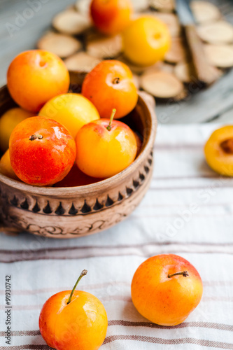 yellow plums in pottery on wooden table, rustic, healthy food, r