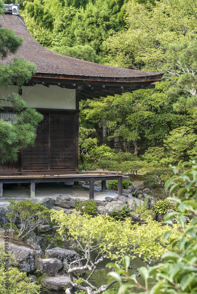 Obraz premium A traditional Japanese wooden building surrounded by trees in a park