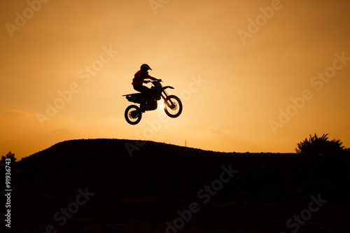 motorcycle silhouette are jumping on sunset