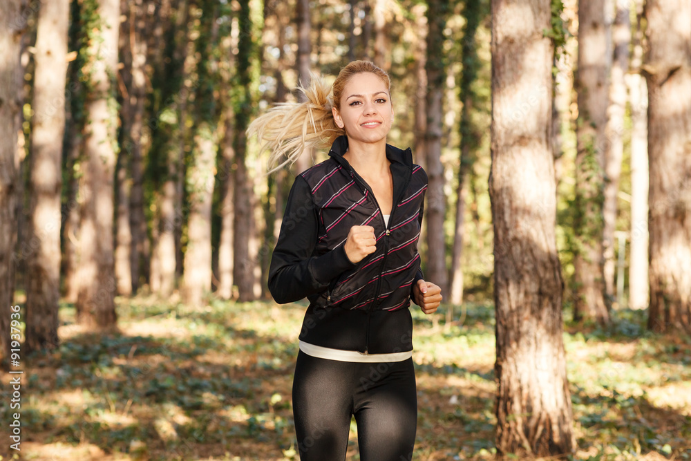 Beautiful young woman running through the park Beautiful young woman running through the park
