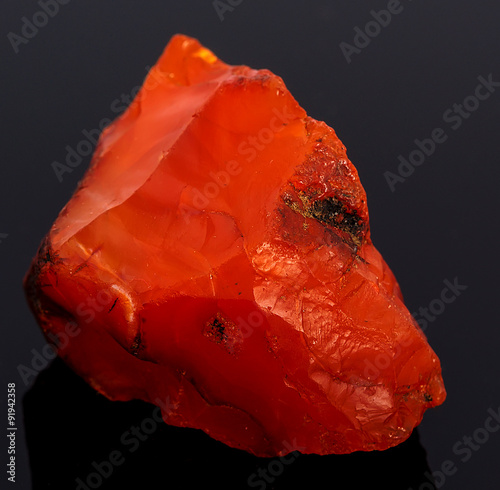 Rough red carnelian rock isolated on black background