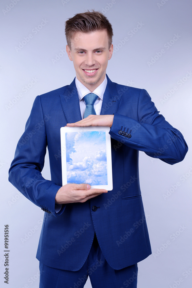 Businessman holding tablet PC with sky in screen. Cloud computing concept Businessman holding tablet PC with sky in screen. Cloud computing concept