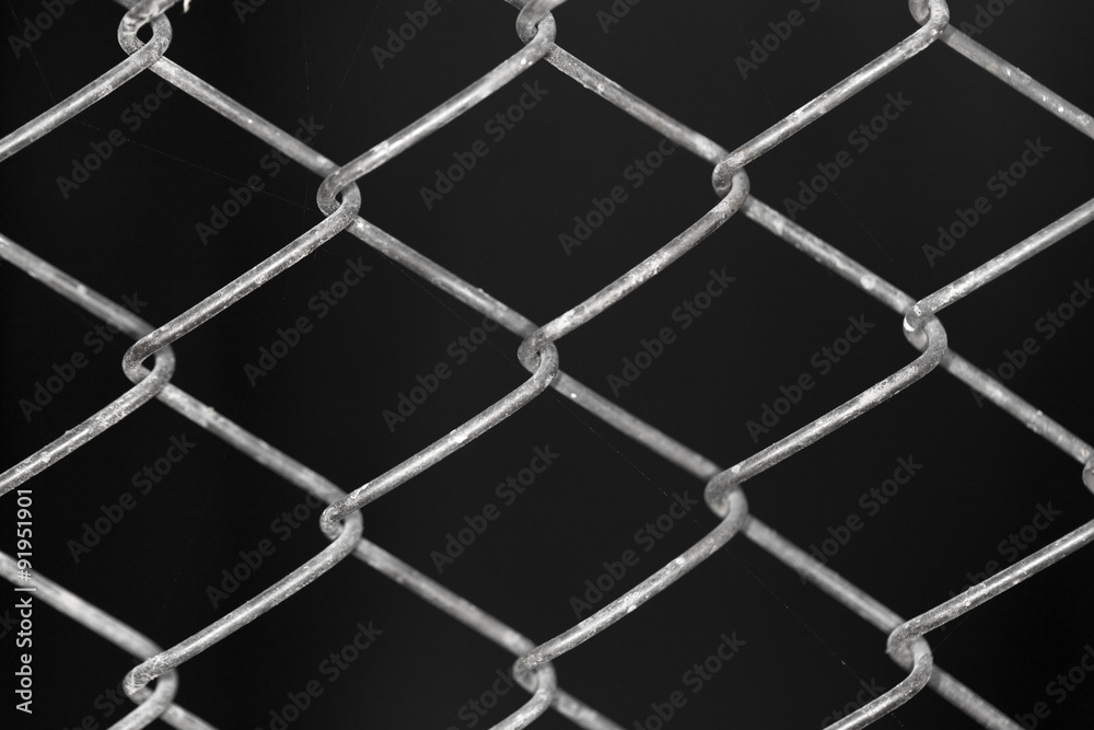Naklejka premium metal grid on a black background background