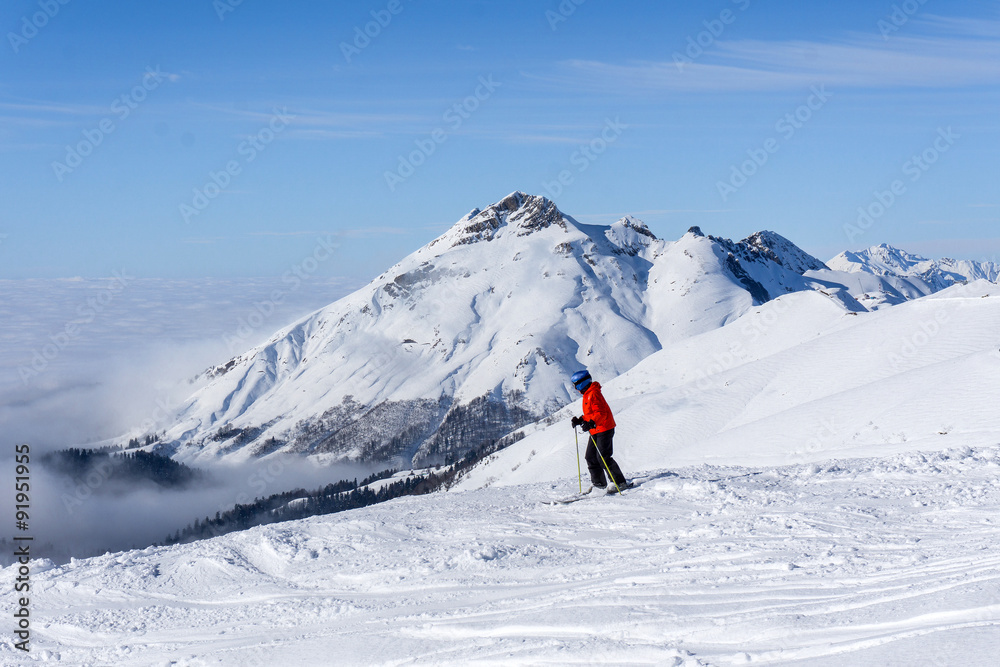 skier on top of mountain above the clouds