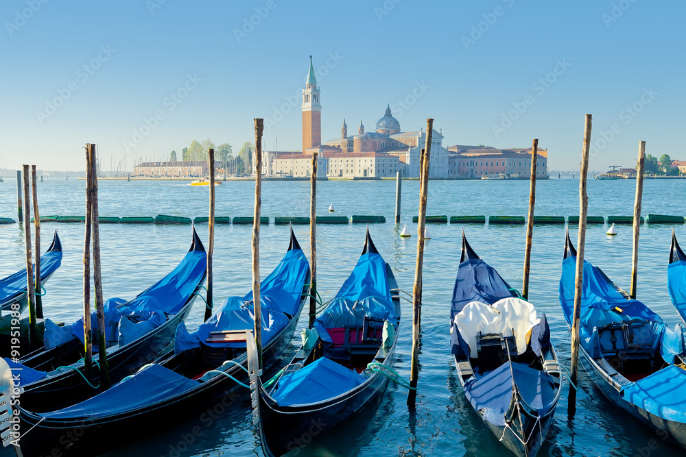 Gondolas moored by Saint Mark square with view Church of San Giorgio Maggiore in the background. Venice, Italy