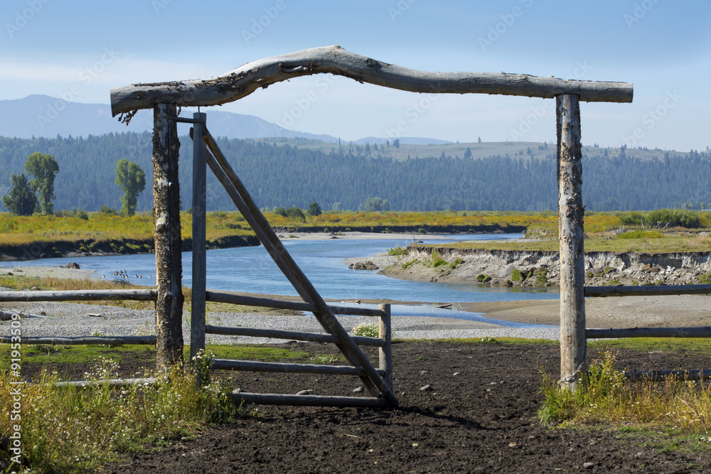 Ranch entry gate in pasture, bank of Buffalo Fork River, Wyoming